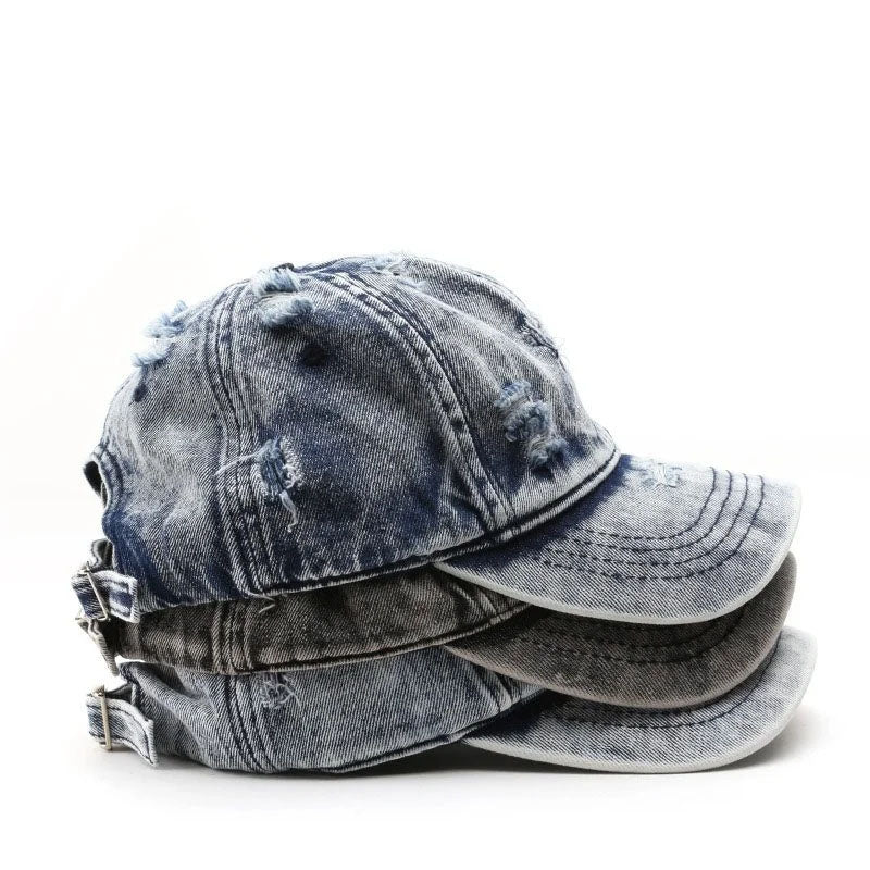 Stack of distressed denim caps on a white background