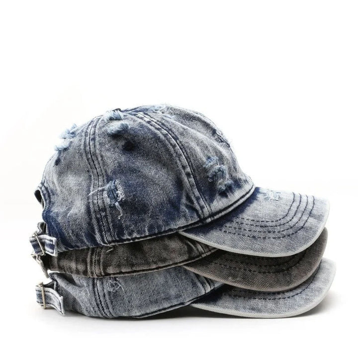 Stack of distressed denim caps on a white background