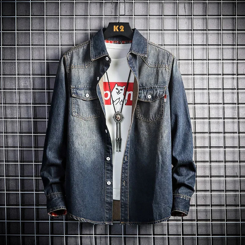 Denim jacket over a white t-shirt with a graphic design on a tiled wall background