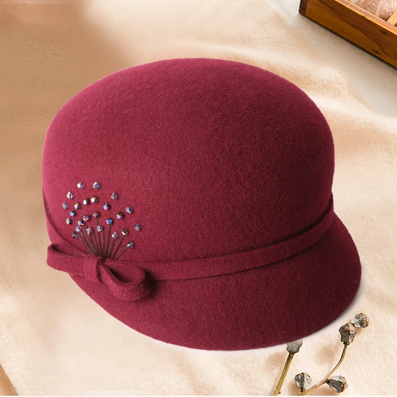Maroon hat with decorative elements on a beige surface