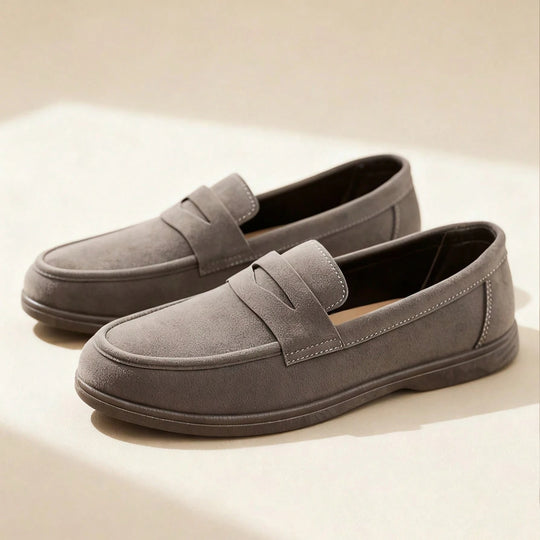 Pair of gray loafers on a light beige background