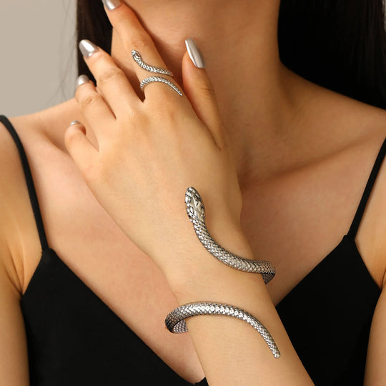 Silver snake-shaped bracelet on a person's wrist with a neutral background