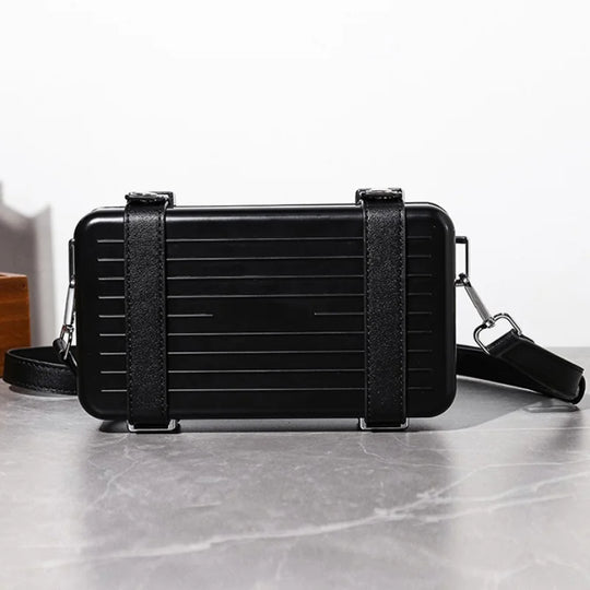 Black rectangular bag with a strap on a light gray surface