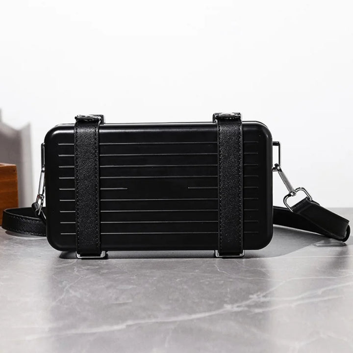 Black rectangular bag with a strap on a light gray surface