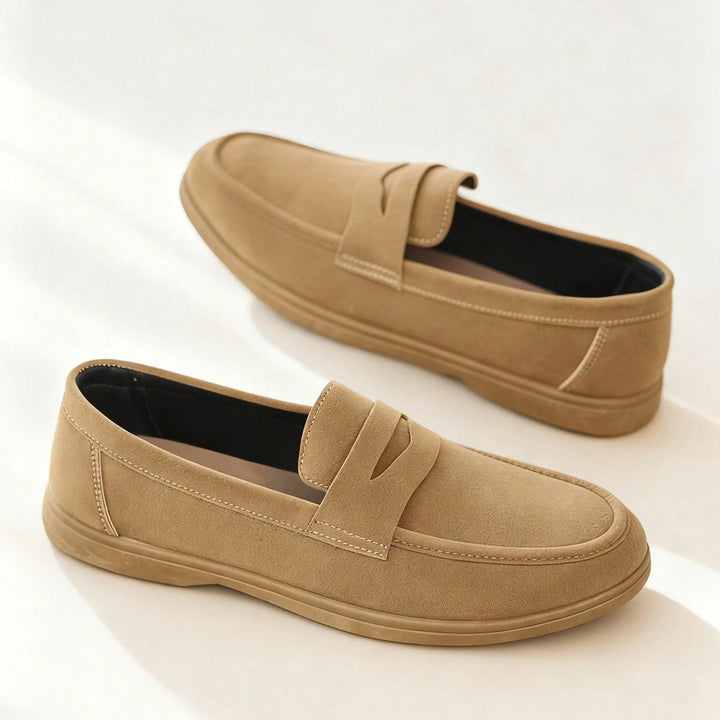 Pair of tan loafers on a white background