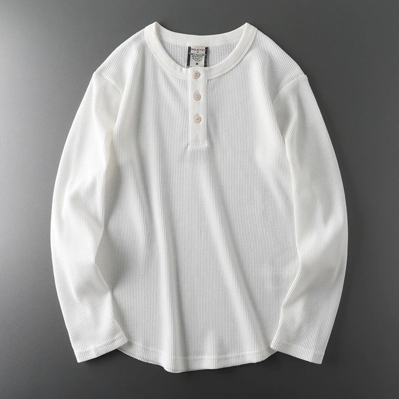 White ribbed long-sleeve shirt on a gray background
