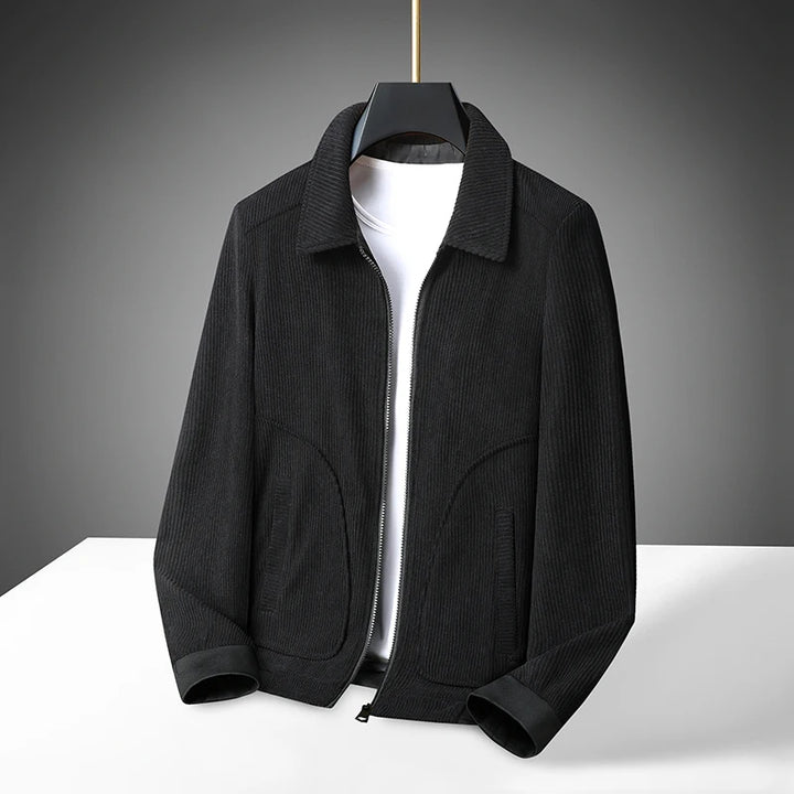 A corduroy coat jacket with a classic lapel design, displayed on a mannequin against a dark background.