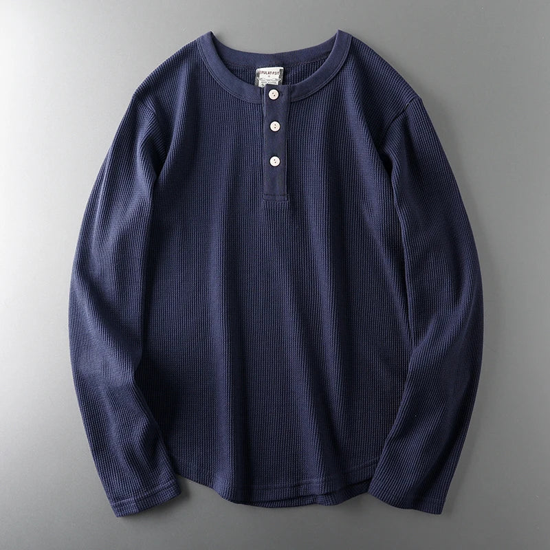 Navy long-sleeve shirt with buttons on a gray background