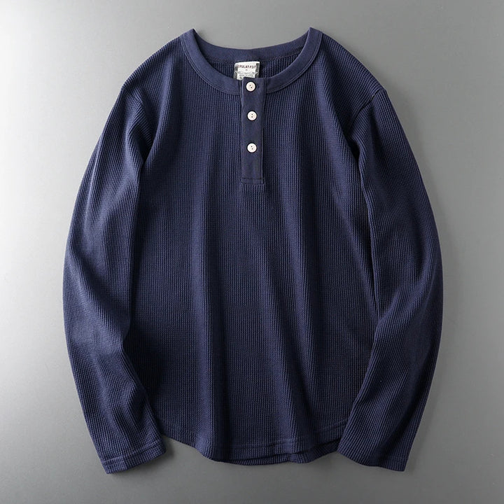 Navy long-sleeve shirt with buttons on a gray background