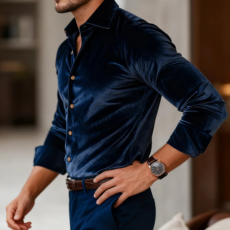 Man wearing a dark blue velvet shirt with a blurred indoor background