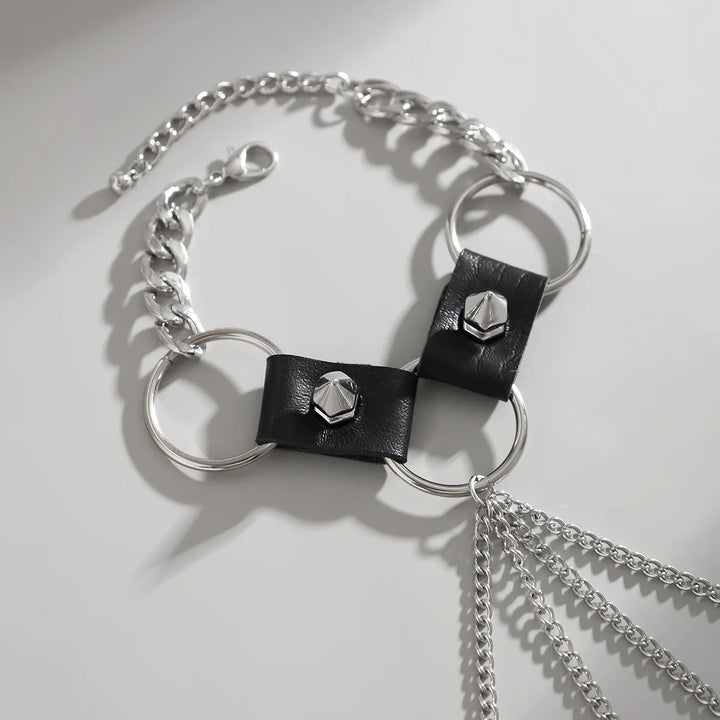 Bracelet with black leather straps and silver chain on a light gray background