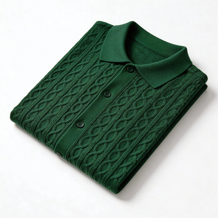 Folded green cable knit sweater on a white background
