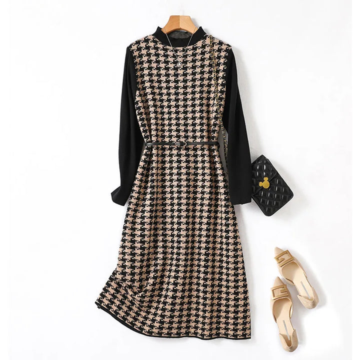 A checkered knit dress in beige and black colors, featuring a round neckline, a belted waist, and midi length. It is displayed alongside a brown belt and beige open-toe platform shoes.
