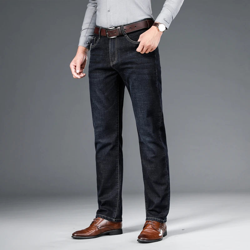Person wearing dark jeans with a gray background