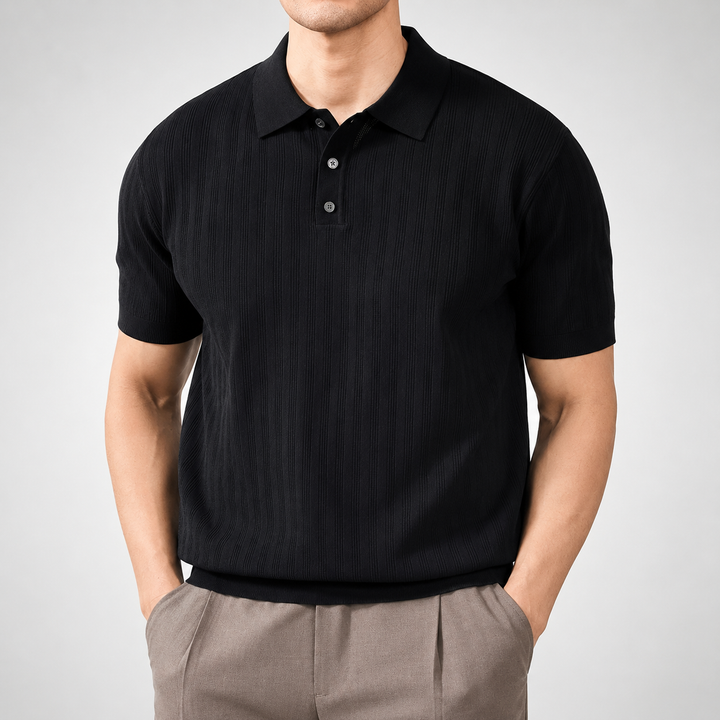 Person wearing a black polo shirt and beige pants on a gray background