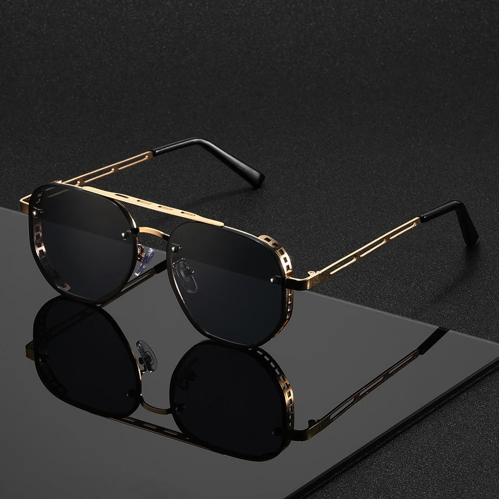 Gold-framed sunglasses with black lenses on a reflective surface
