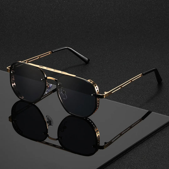 Gold-framed sunglasses with black lenses on a reflective surface