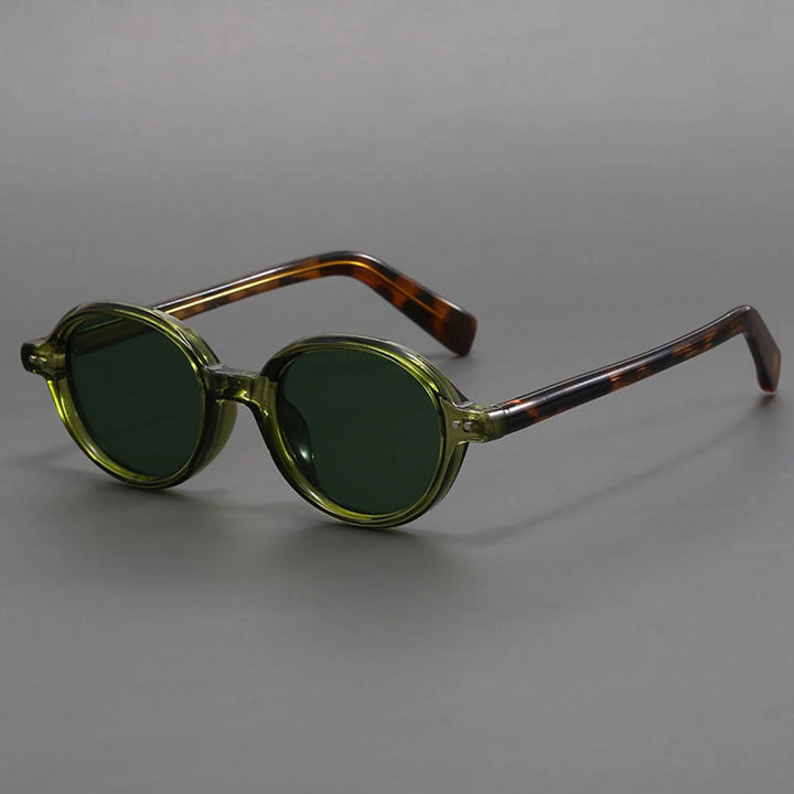 A pair of oval-shaped sunglasses with green tinted lenses and a patterned frame, displayed against a gray background.