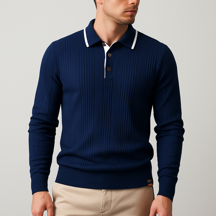 Man wearing a navy blue sweater with white collar and beige pants on a gray background