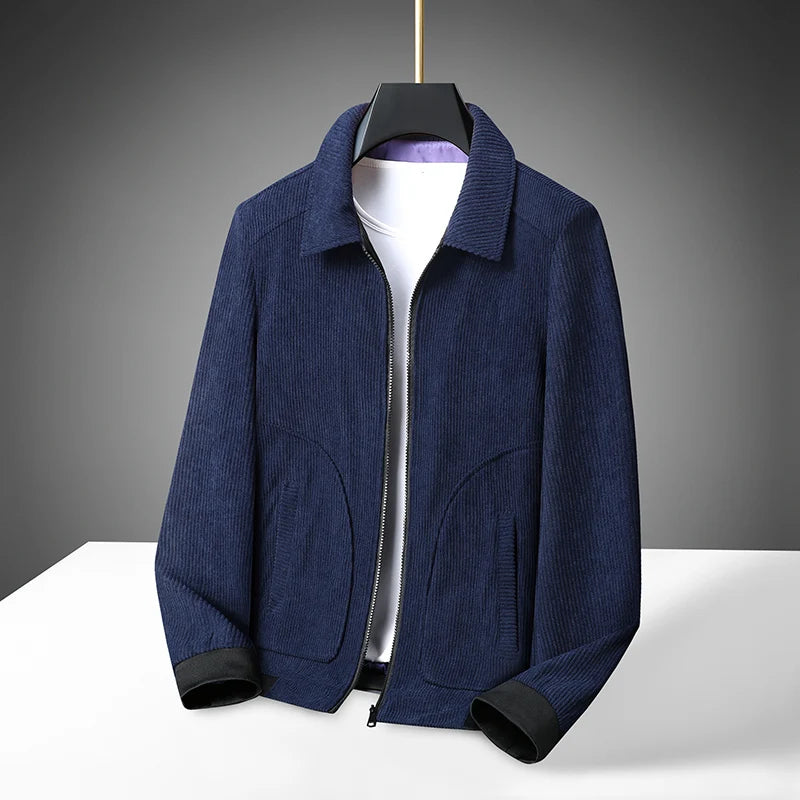 A navy blue corduroy coat jacket with a classic lapel, displayed on a white hanger against a dark background.