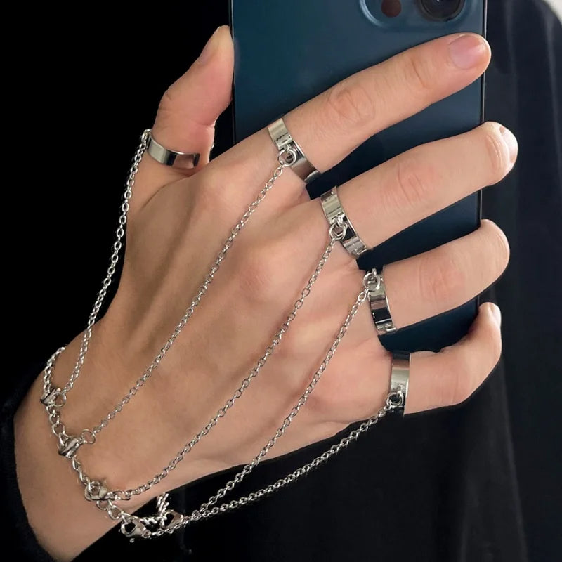 Hand holding a phone with silver chain accessory against a black background